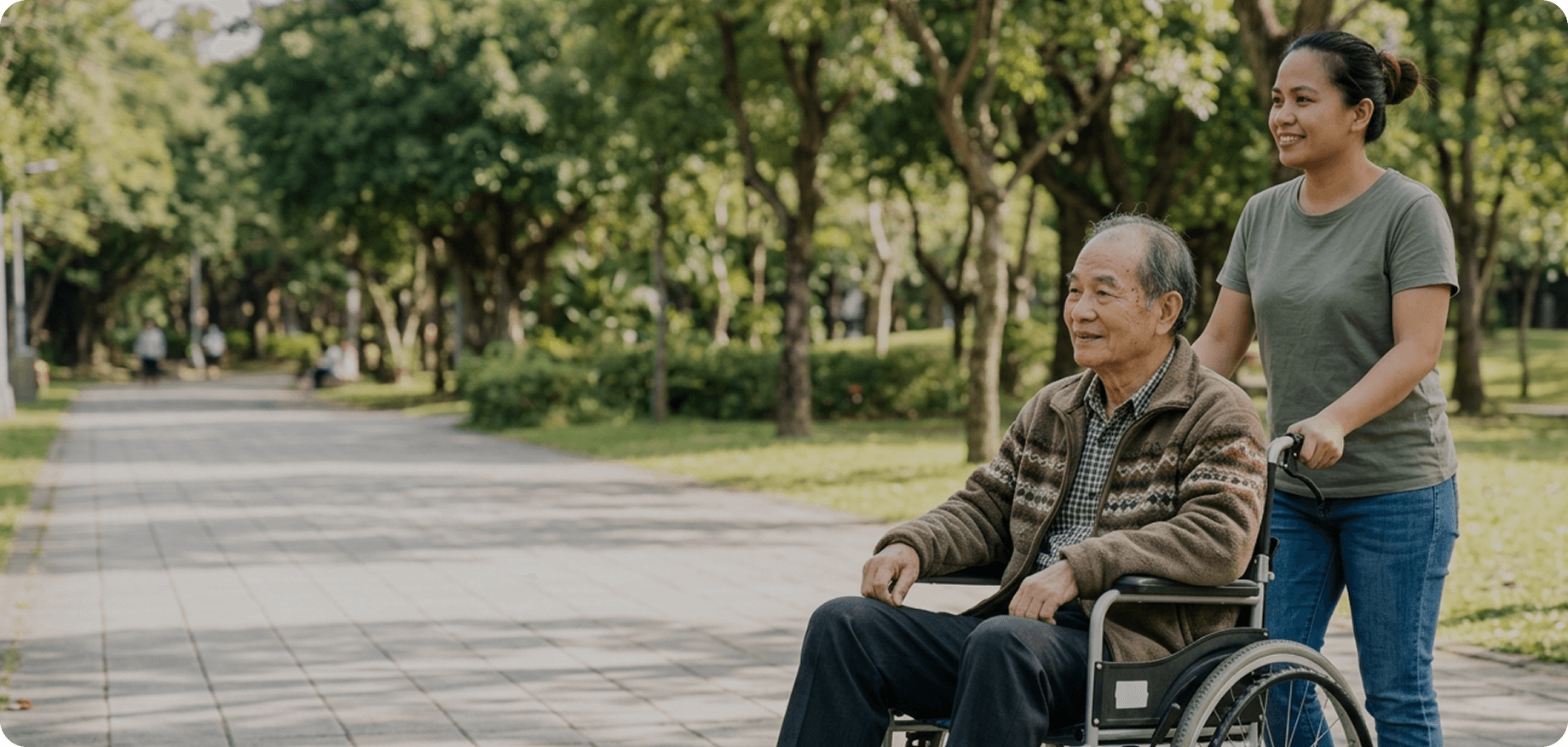 照護者陪伴坐輪椅的長輩在公園散步